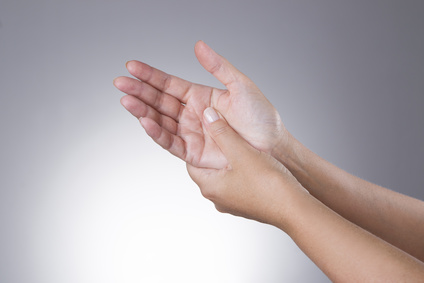 Pain in the joints of the hands on a gray background. Carpal tunnel syndrome. Care of male hands